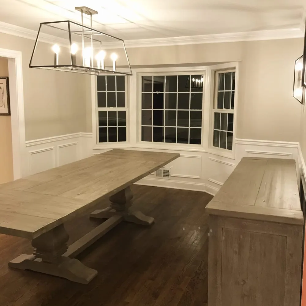 Dining room with painted wainscoting, fresh walls and a bay window