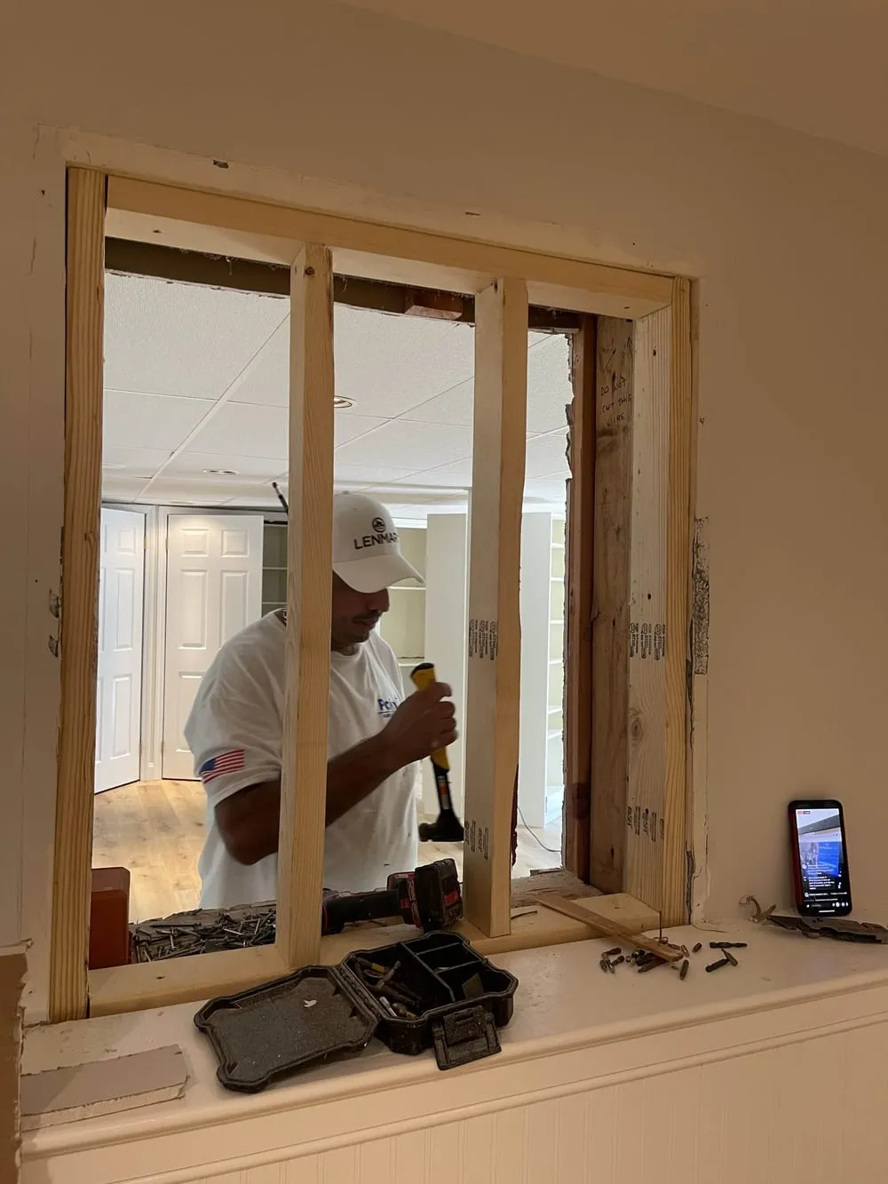Carpenter framing a new pass-through opening in an interior wall