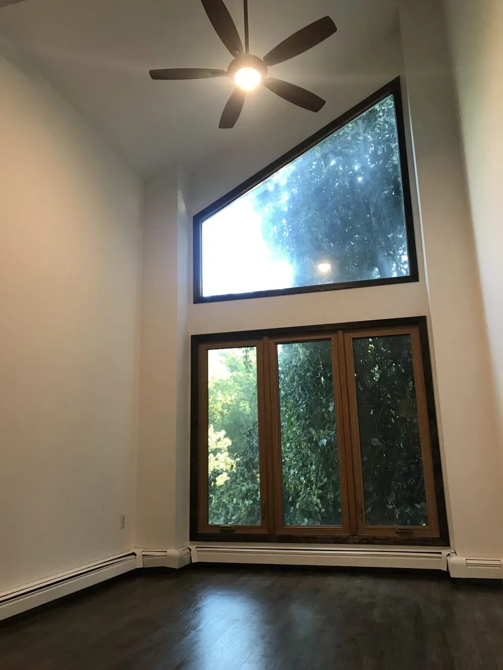 Two-story room with freshly painted walls and a tall picture window