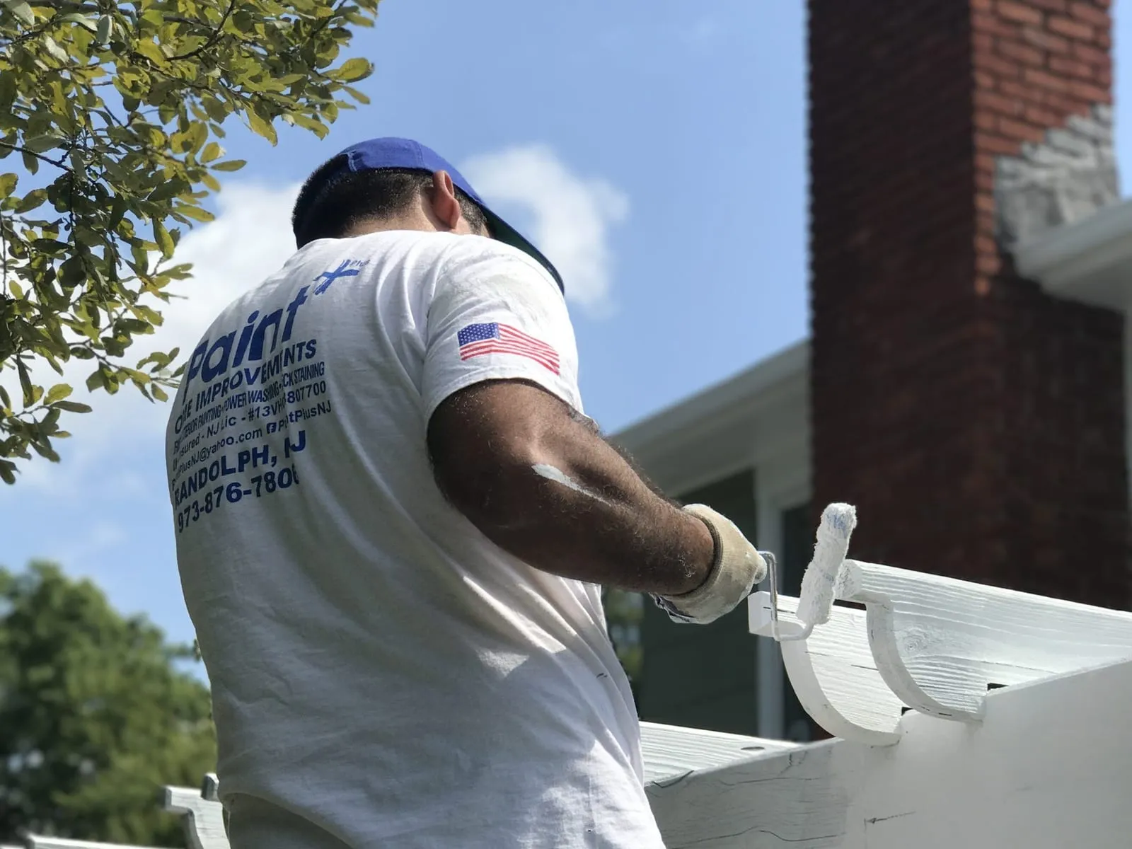 Paint Plus painter painting the white trim of an outdoor pergola