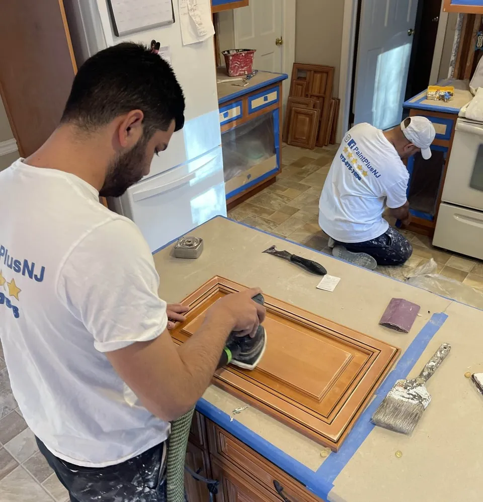 Paint Plus crew sanding kitchen cabinet doors before refinishing in Bedminster, NJ