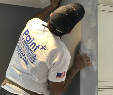 Paint Plus painter smoothing a wall before painting in Bernardsville, NJ