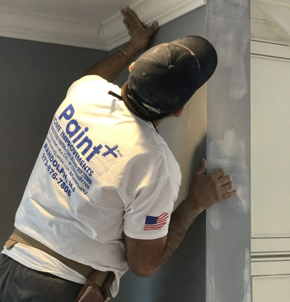 Paint Plus painter smoothing a wall before painting in Bernardsville, NJ