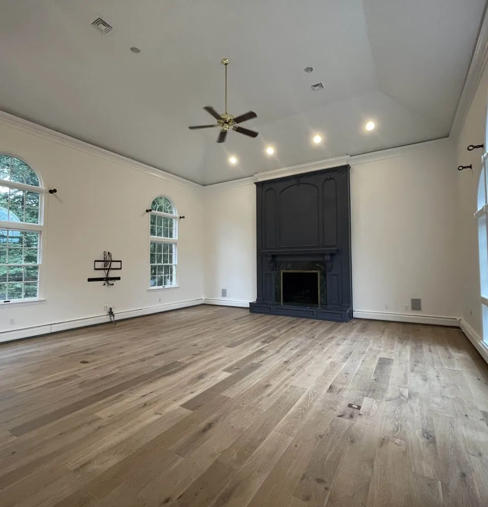 Great room with a painted fireplace surround, vaulted ceiling and arched windows, painted by Paint Plus in Far Hills, NJ