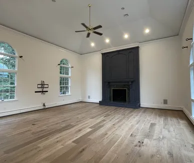 Great room with a painted fireplace surround, vaulted ceiling and arched windows, painted by Paint Plus in Far Hills, NJ