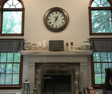 Living room fireplace wall with painted mantel and arched windows, painted by Paint Plus in Mendham, NJ