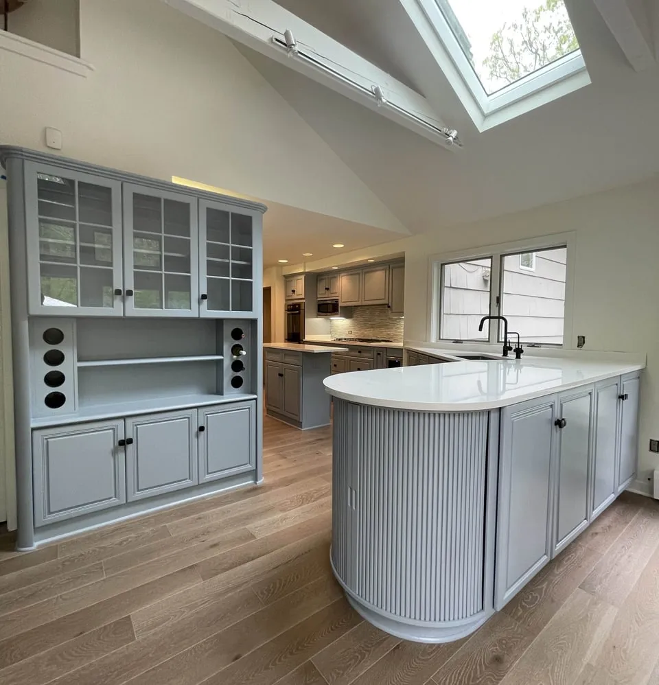 Kitchen with gray painted cabinets, a glass-front hutch and a fluted island, refinished by Paint Plus in Morristown, NJ