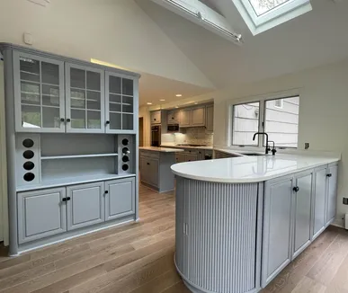 Kitchen with gray painted cabinets, a glass-front hutch and a fluted island, refinished by Paint Plus in Morristown, NJ