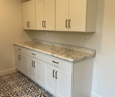 White shaker cabinets and marble-look counters in a remodeled laundry room by Paint Plus in Mountain Lakes, NJ