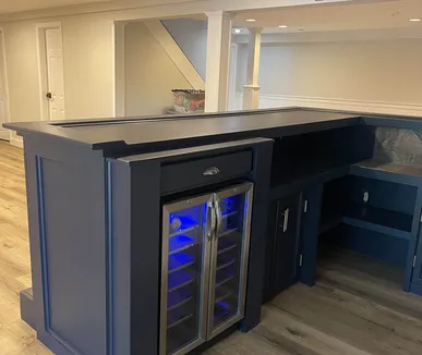 Custom navy basement bar with a built-in wine fridge, built by Paint Plus in Randolph, NJ