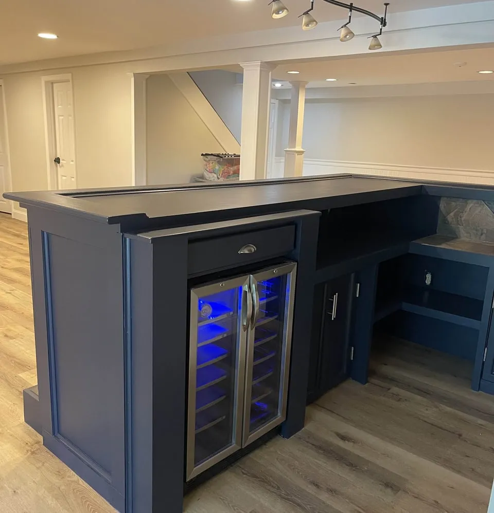 Custom navy basement bar with a built-in wine fridge, built by Paint Plus in Randolph, NJ