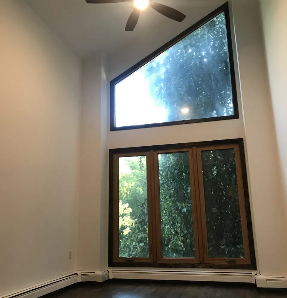 Two-story room with fresh white walls and a tall picture window, painted by Paint Plus in Short Hills, NJ