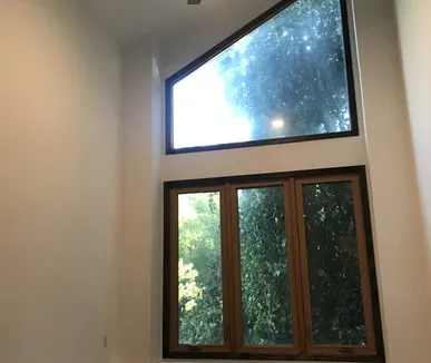 Two-story room with fresh white walls and a tall picture window, painted by Paint Plus in Short Hills, NJ